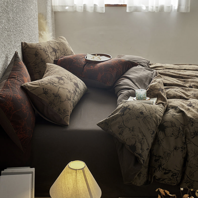 Brown cotton bedding with black botanical motifs.