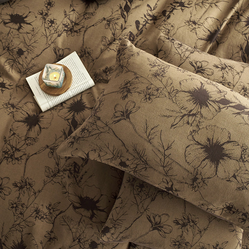 Brown cotton bedding with black botanical motifs.