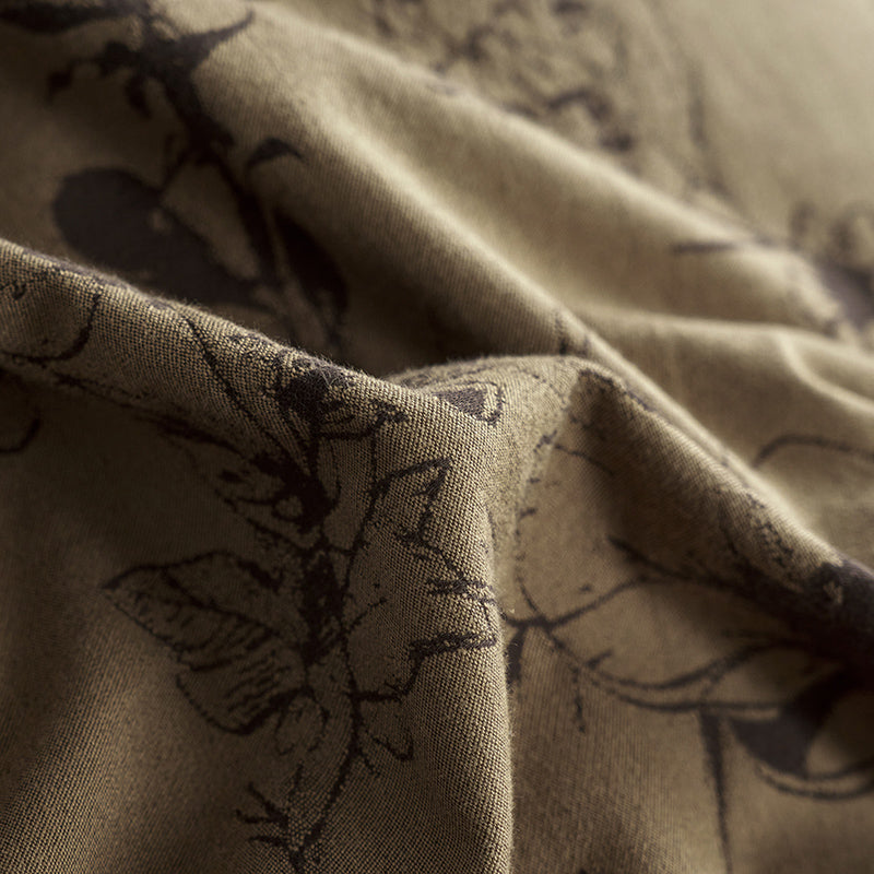 Brown cotton bedding with black botanical motifs.