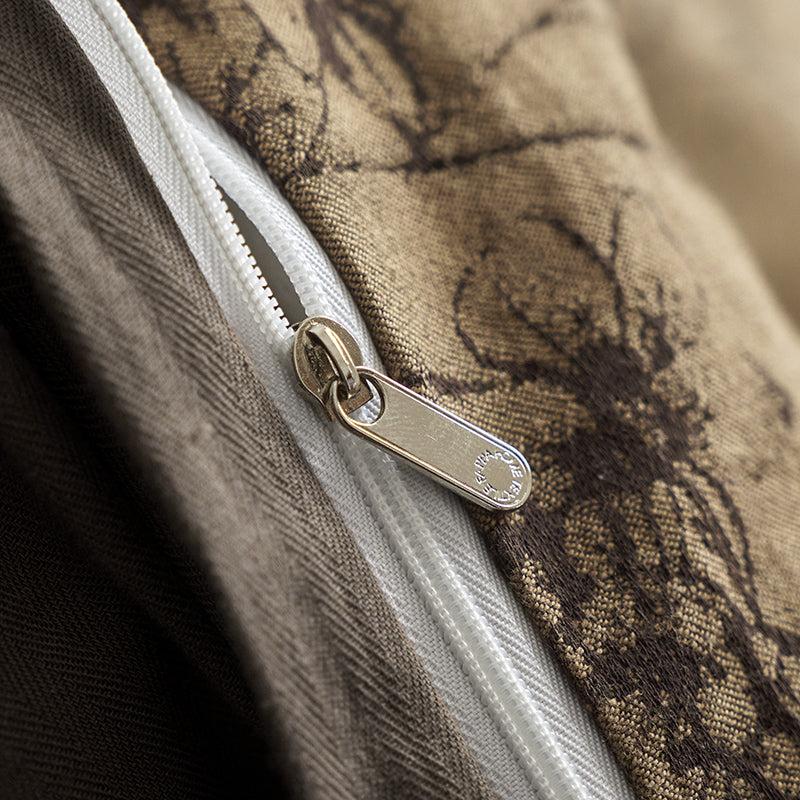 Brown cotton bedding with black botanical motifs.