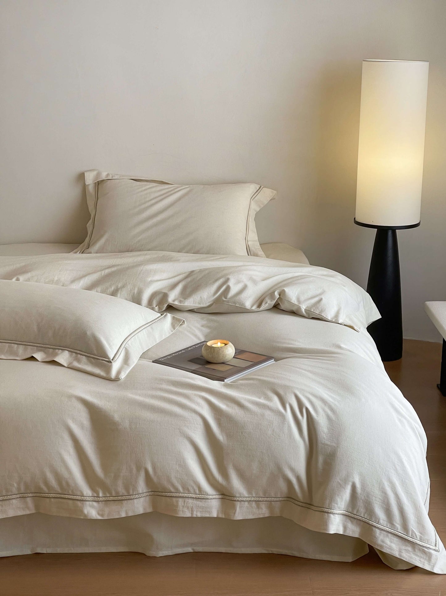 Neutral cream linen bedding with tonal trim accents.