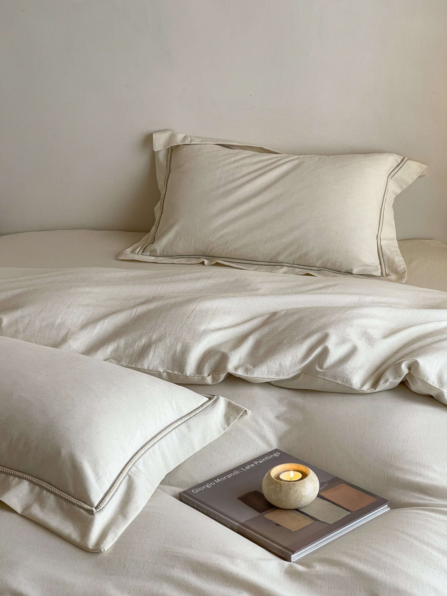 Neutral cream linen bedding with tonal trim accents.