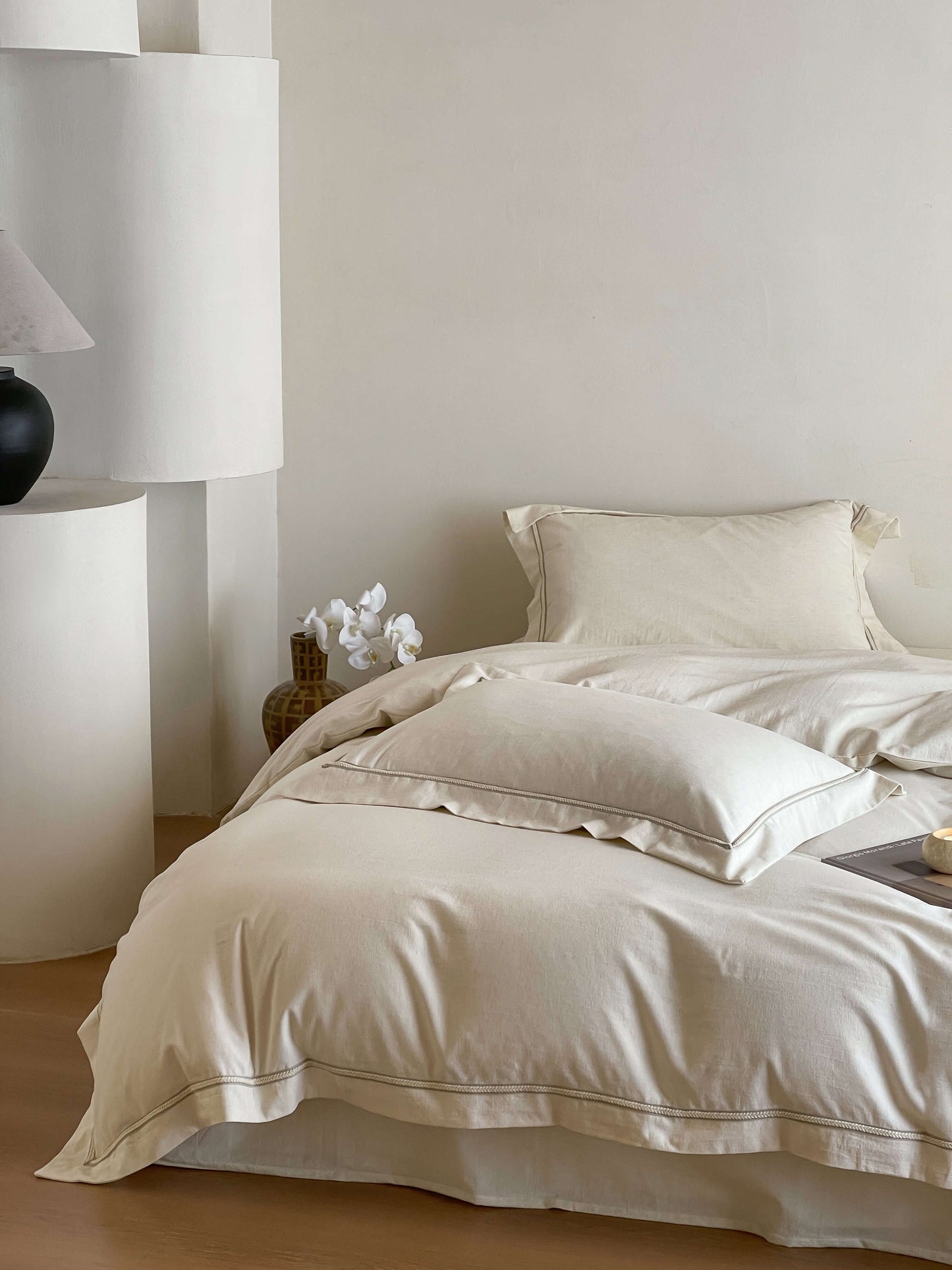 Neutral cream linen bedding with tonal trim accents.