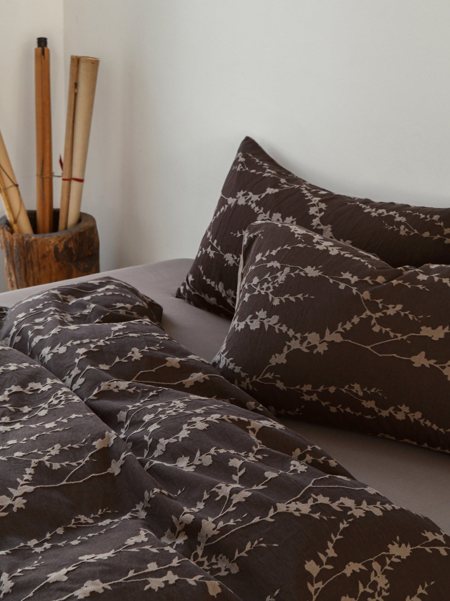 Taupe vine-patterned bedding set on a cozy bed, featuring elegant natural motifs for a serene bedroom decor.