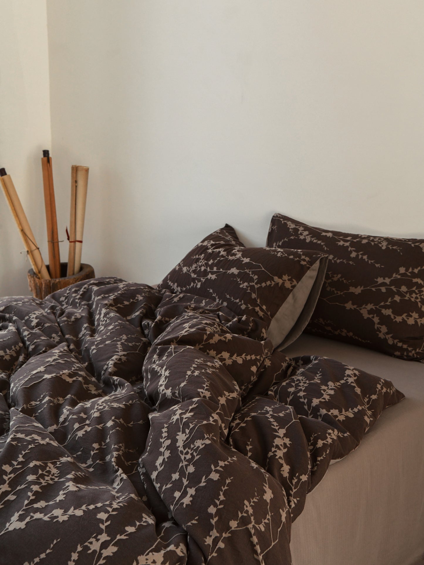 Taupe vine-patterned bedding set on a neatly made bed, showcasing organic sophistication and comfort.