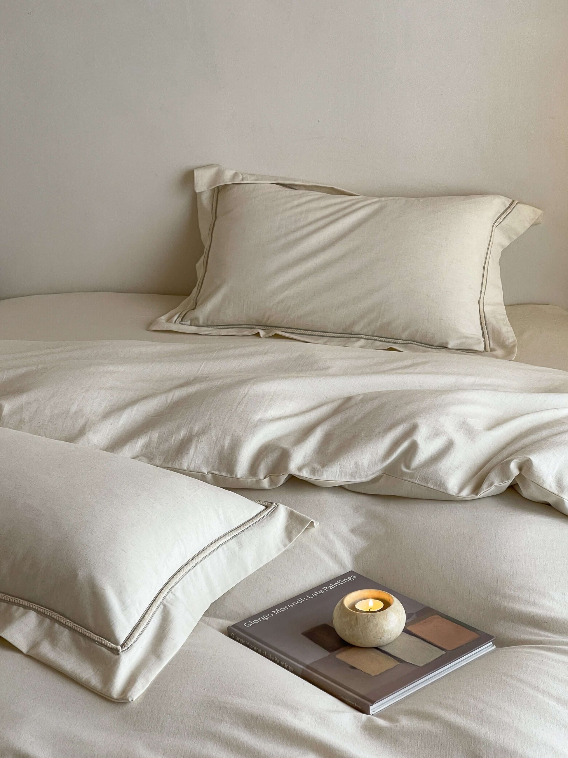 Neutral cream linen bedding with tonal trim accents.