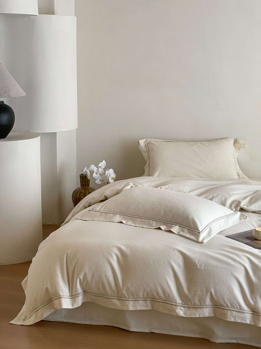 Neutral cream linen bedding with tonal trim accents.