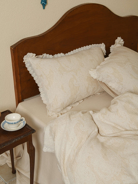 Neutral beige floral quilt with subtle lace accents in premium linen.